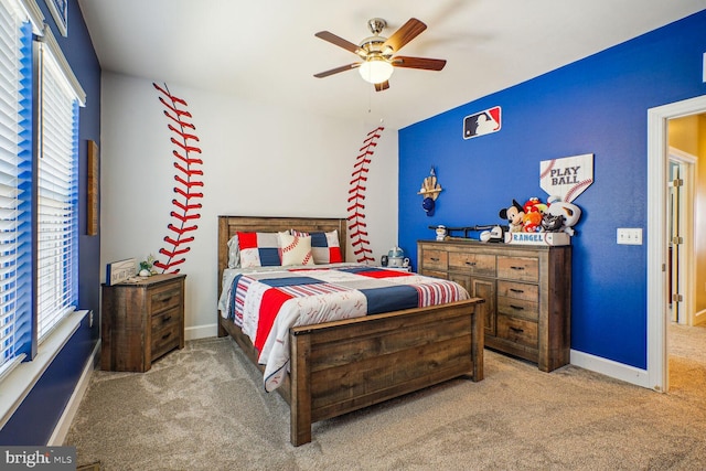 carpeted bedroom featuring baseboards, multiple windows, and a ceiling fan