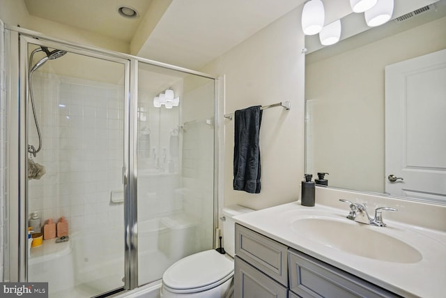 bathroom with visible vents, vanity, toilet, and a shower stall