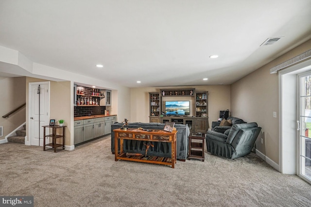 living room featuring visible vents, a dry bar, stairway, carpet floors, and baseboards