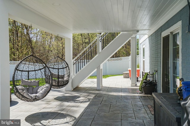 view of patio featuring stairs and fence