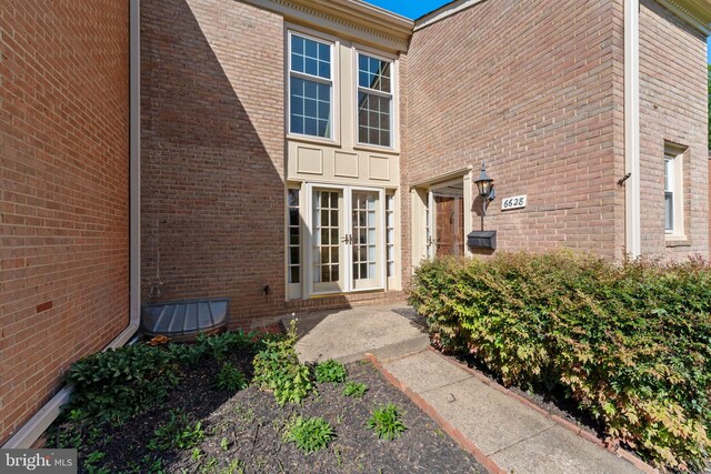 entrance to property featuring french doors and brick siding