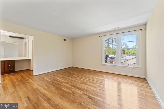 interior space featuring baseboards, visible vents, and light wood-style floors