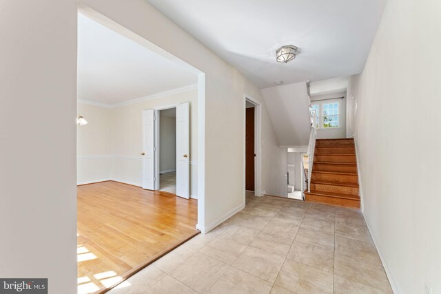 entryway featuring crown molding, baseboards, and stairs