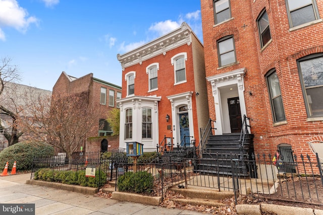 view of front facade with a fenced front yard and brick siding