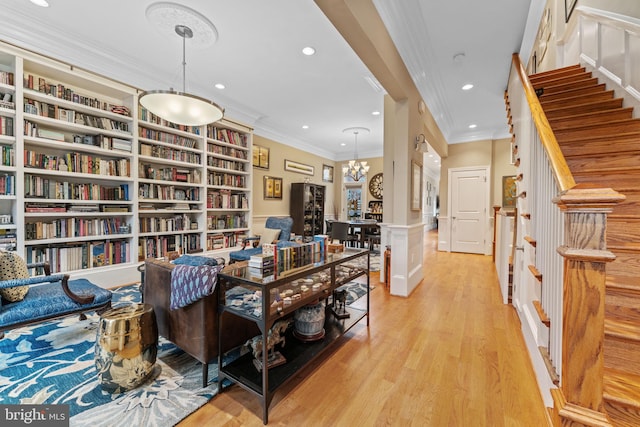 sitting room with ornamental molding, recessed lighting, and stairs