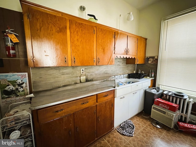 207 E Howard St, Bellefonte, PA 16823 - kitchen featuring tasteful backsplash, brown cabinetry, light countertops, and a sink