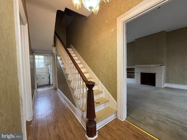 207 E Howard St, Bellefonte, PA 16823 - stairway with baseboards, wood finished floors, and a fireplace