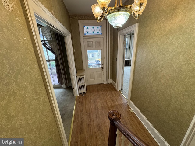 207 E Howard St, Bellefonte, PA 16823 - entryway featuring radiator, wood finished floors, wallpapered walls, a notable chandelier, and baseboards