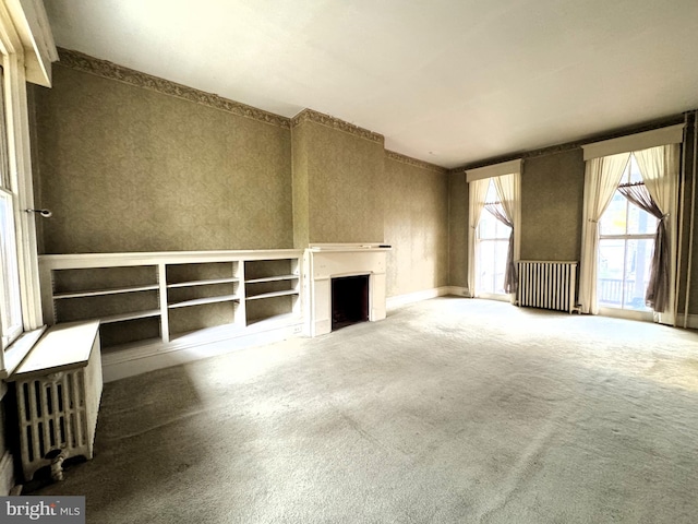 207 E Howard St, Bellefonte, PA 16823 - unfurnished living room featuring baseboards, radiator, carpet, and a fireplace