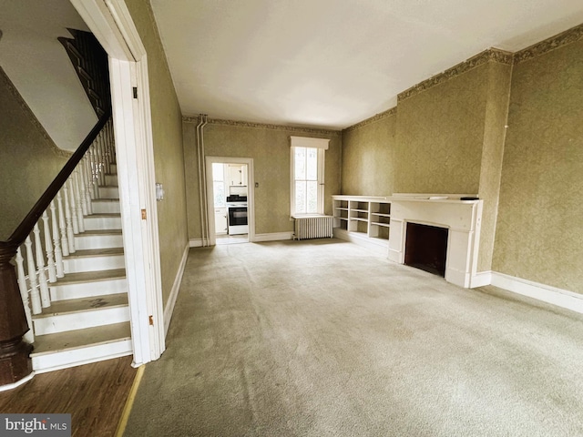 207 E Howard St, Bellefonte, PA 16823 - unfurnished living room featuring baseboards, a fireplace, radiator heating unit, stairs, and carpet