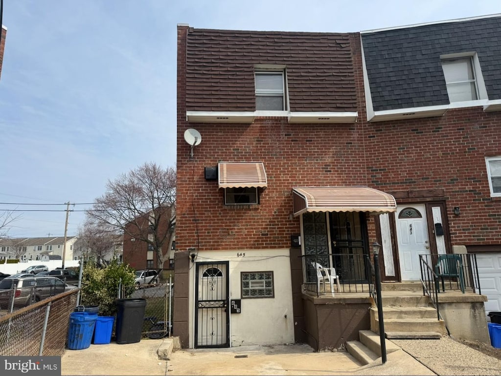 view of front facade featuring fence and brick siding