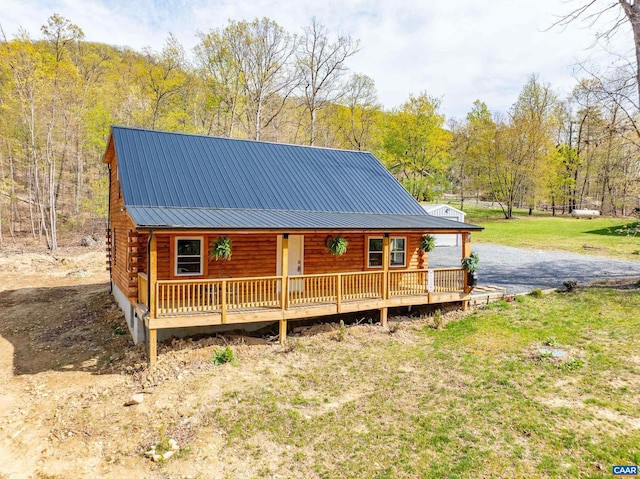 136 Wildwood Ln, Shenandoah, VA 22849 - log-style house featuring a view of trees, a front yard, log exterior, metal roof, and covered porch