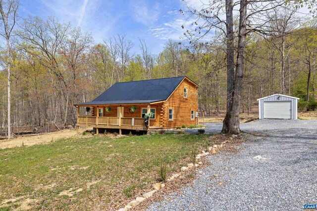 136 Wildwood Ln, Shenandoah, VA 22849 - log-style house featuring metal roof, a garage, an outdoor structure, driveway, and log siding