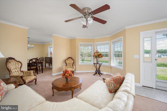 living area with crown molding, ceiling fan with notable chandelier, carpet flooring, and baseboards