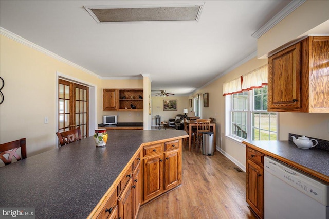 kitchen featuring dishwasher, dark countertops, crown molding, brown cabinetry, and light wood-style flooring