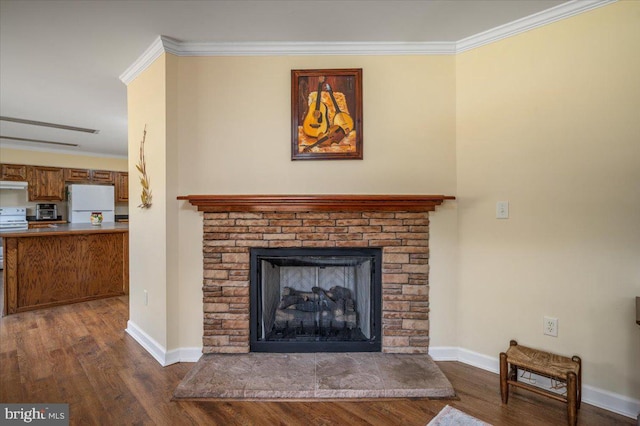 interior details featuring a fireplace, white appliances, crown molding, and wood finished floors
