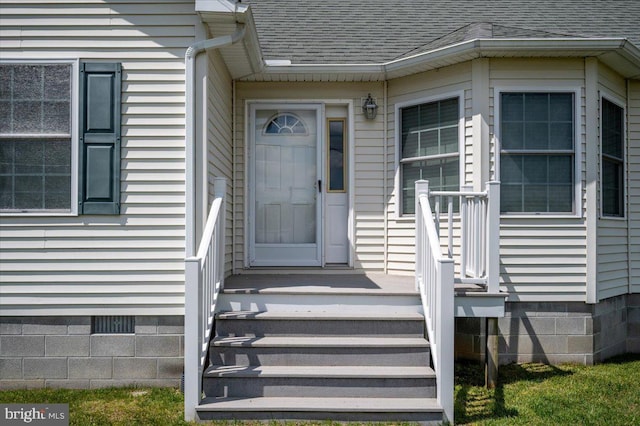 doorway to property with a shingled roof