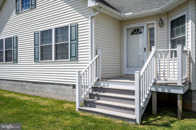doorway to property featuring a shingled roof