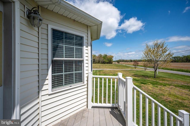 wooden deck with a rural view and a yard