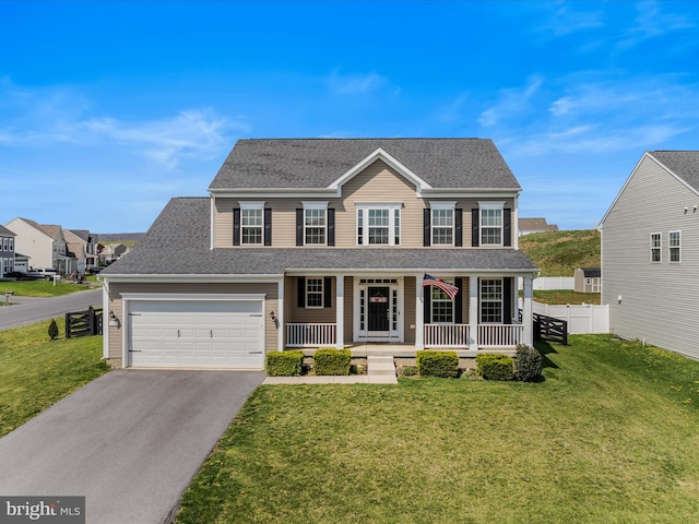 view of front of property with a garage, covered porch, a front yard, fence, and driveway