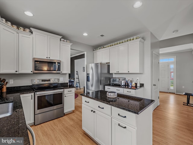 kitchen featuring light wood-style flooring, white cabinetry, visible vents, and appliances with stainless steel finishes