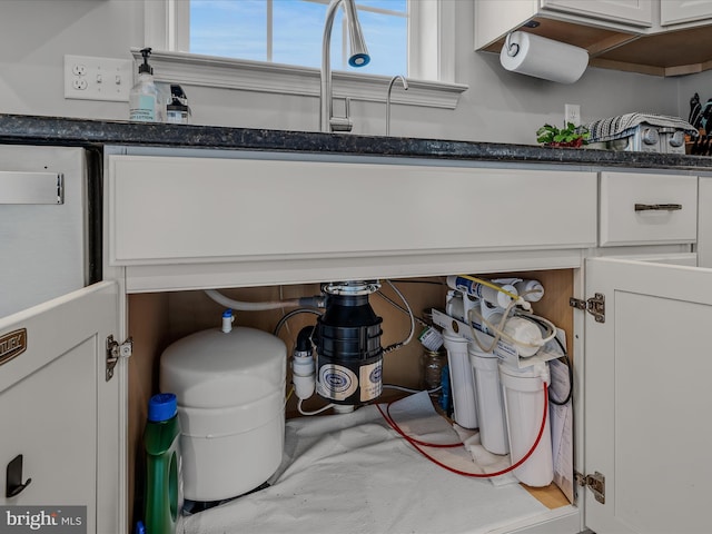 details featuring dark stone countertops and white cabinets