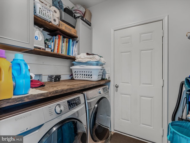 laundry room featuring separate washer and dryer and cabinet space