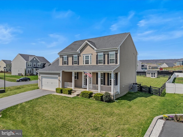view of front of house with aphalt driveway, a porch, a front yard, fence, and a residential view