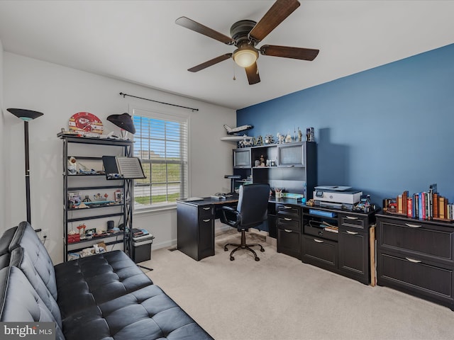 carpeted office with baseboards and a ceiling fan