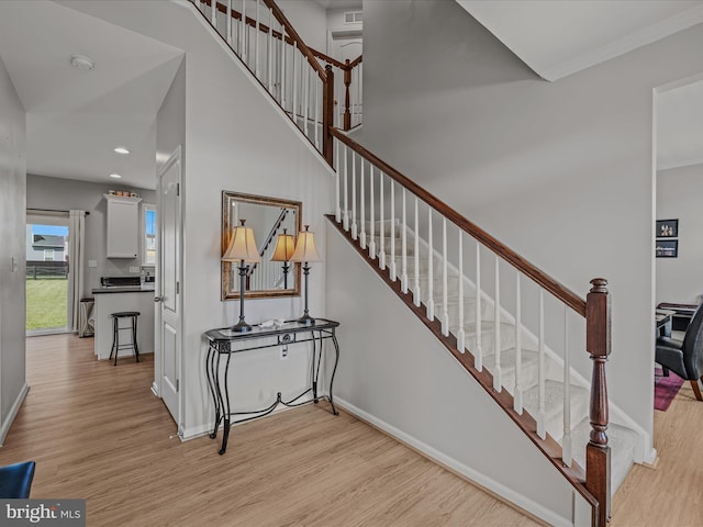 stairway featuring baseboards, recessed lighting, and wood finished floors