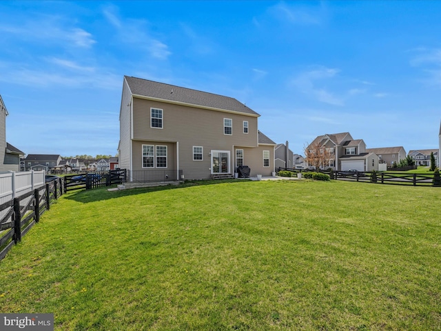rear view of house featuring a yard, a fenced backyard, and a residential view
