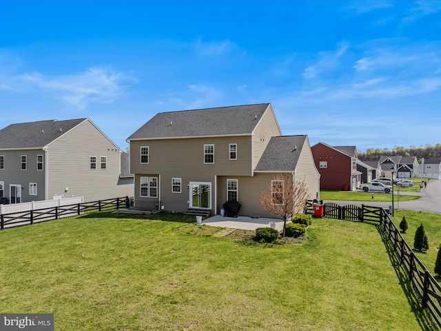 rear view of property with a fenced backyard, a patio area, and a lawn