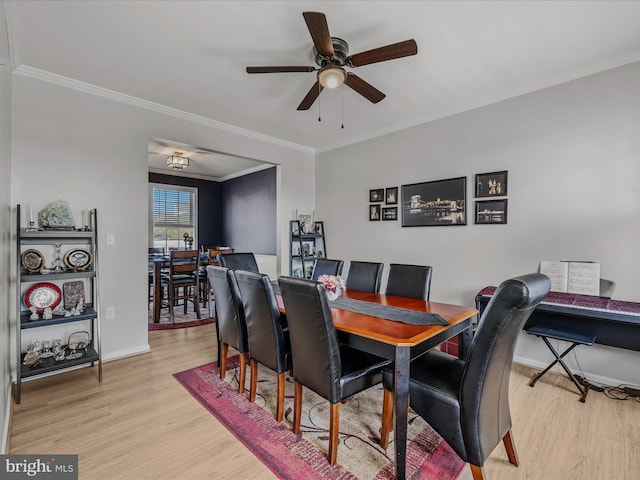 dining area with crown molding, light wood finished floors, baseboards, and a ceiling fan