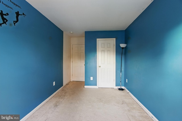 carpeted spare room featuring baseboards