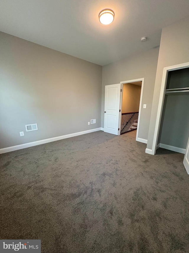 2241 E Preston St, Baltimore, MD 21213 - unfurnished bedroom with dark colored carpet, baseboards, and a closet