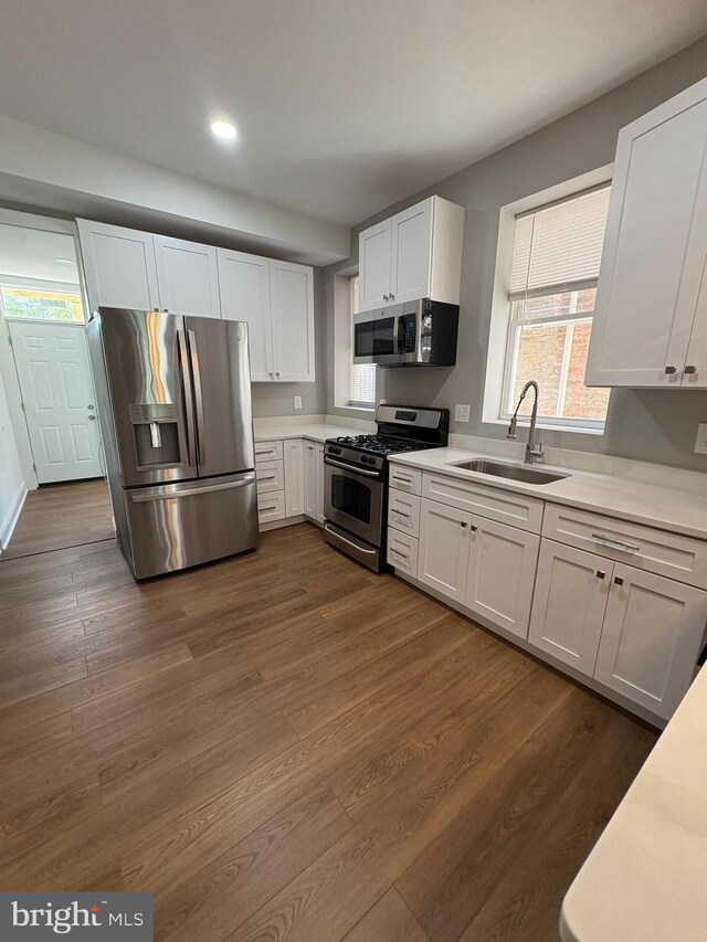 2241 E Preston St, Baltimore, MD 21213 - kitchen featuring appliances with stainless steel finishes, a sink, light countertops, white cabinets, and dark wood-type flooring