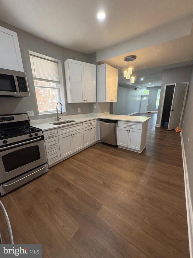 2241 E Preston St, Baltimore, MD 21213 - kitchen with stainless steel appliances, a sink, a peninsula, dark wood finished floors, and recessed lighting