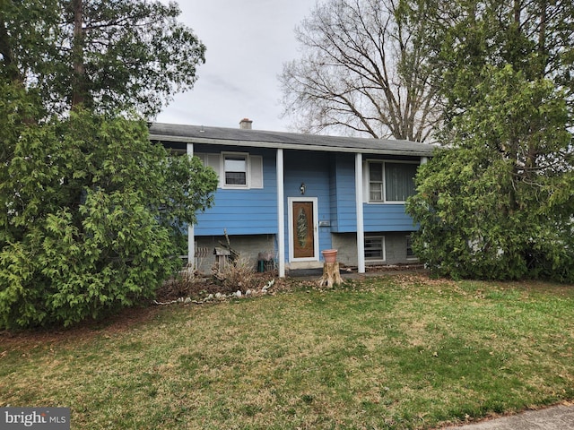 raised ranch with a chimney and a front lawn