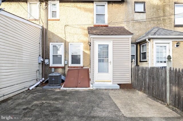 206 Paris Ave, Brooklawn, NJ 08030 - property entrance with fence, a shingled roof, stucco siding, and central air condition unit