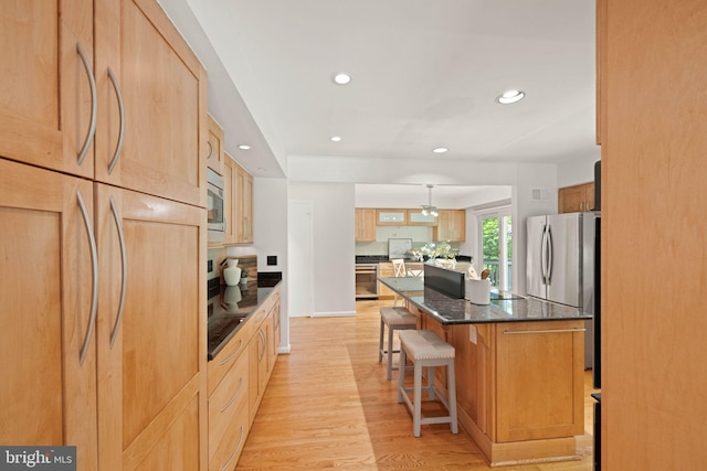 1925 Upper Lake Dr, Reston, VA 20191 - kitchen featuring appliances with stainless steel finishes, a center island, a kitchen bar, light wood-type flooring, and recessed lighting