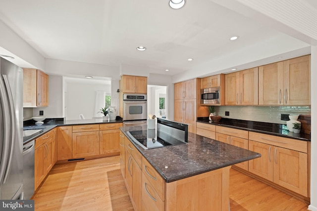 1925 Upper Lake Dr, Reston, VA 20191 - kitchen featuring appliances with stainless steel finishes, a kitchen island, light wood-type flooring, tasteful backsplash, and light brown cabinetry