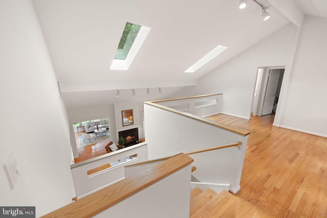 1925 Upper Lake Dr, Reston, VA 20191 - hall with a skylight, track lighting, light wood finished floors, an upstairs landing, and beamed ceiling