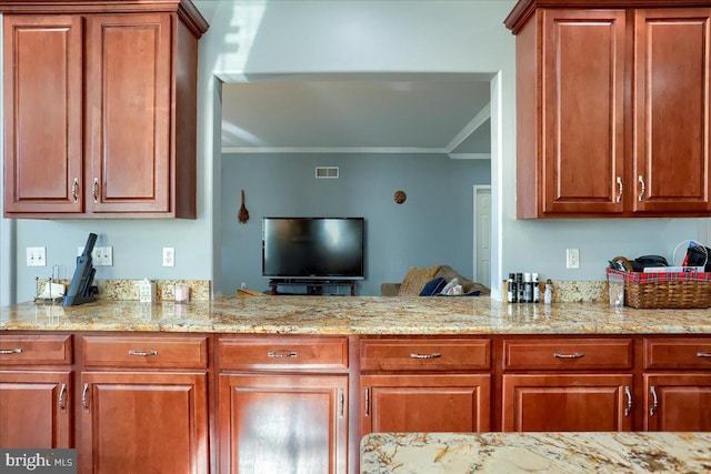 704 Goddard Dr, York, PA 17402 - kitchen featuring ornamental molding, brown cabinetry, light stone counters, and visible vents