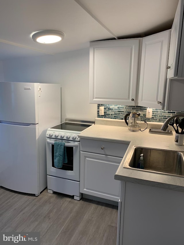 15 Higginsville Ln, Mount Royal, NJ 08061 - kitchen featuring a sink, decorative backsplash, white appliances, white cabinets, and wood finished floors
