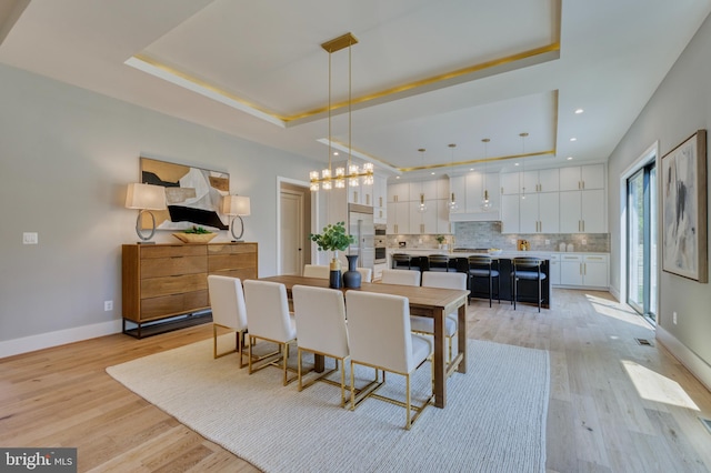 1127 Guilford Ct, Mclean, VA 22101 - dining room featuring a notable chandelier, light wood-style flooring, baseboards, and a raised ceiling
