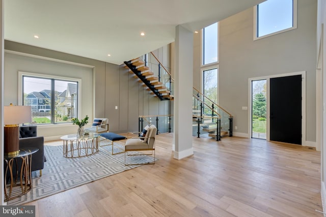1127 Guilford Ct, Mclean, VA 22101 - living area with stairway, a high ceiling, wood finished floors, and a healthy amount of sunlight