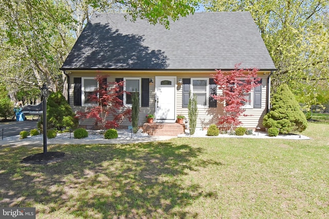 cape cod house with a shingled roof and a front lawn