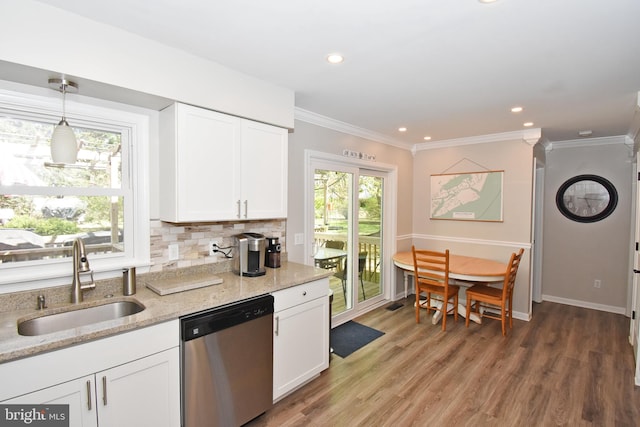 kitchen with light stone countertops, a sink, dishwasher, white cabinetry, and wood finished floors
