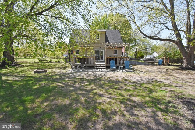 back of house featuring a wooden deck, a pergola, a shingled roof, an outdoor fire pit, and a yard