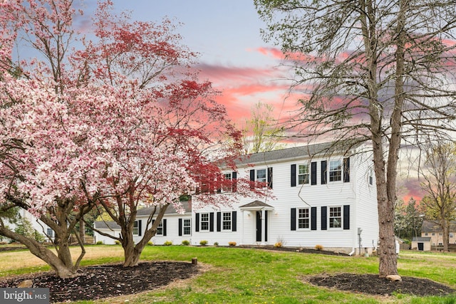 colonial inspired home with a front lawn